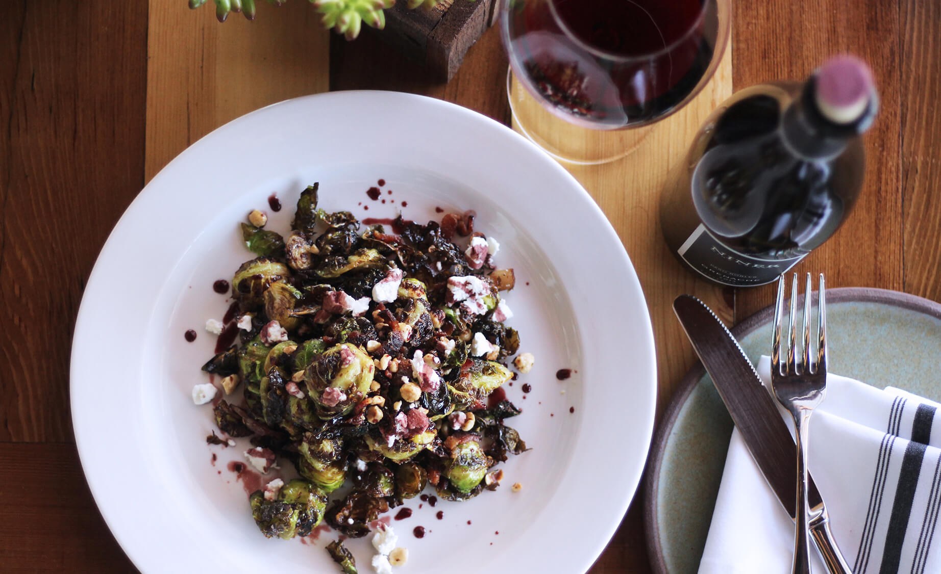 Brussel Sprouts with bacon and apple butter on a white dish