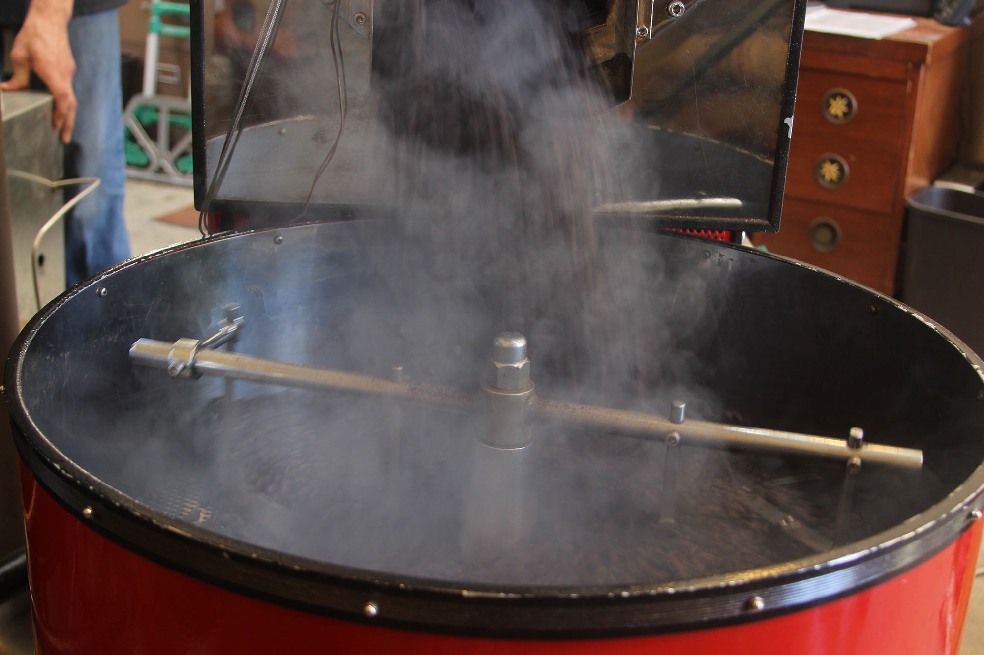 Steam coming off the full turning bin as the fresh-roasted beans begin to cool.