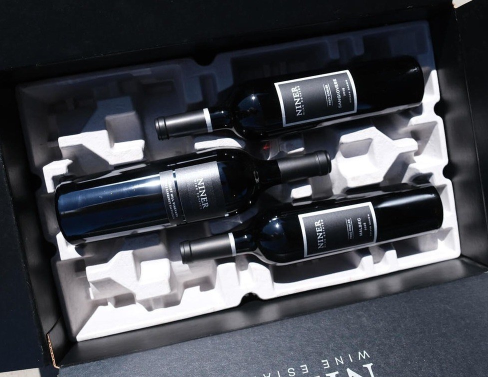 Three bottles of wine in a black shipping box