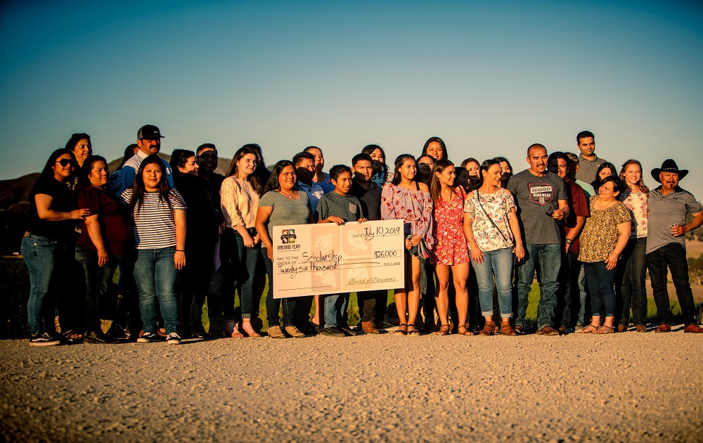 A group of Scholarship awardees holding up a large check